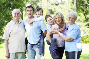 Portrait of a extended happy family standing in the park.