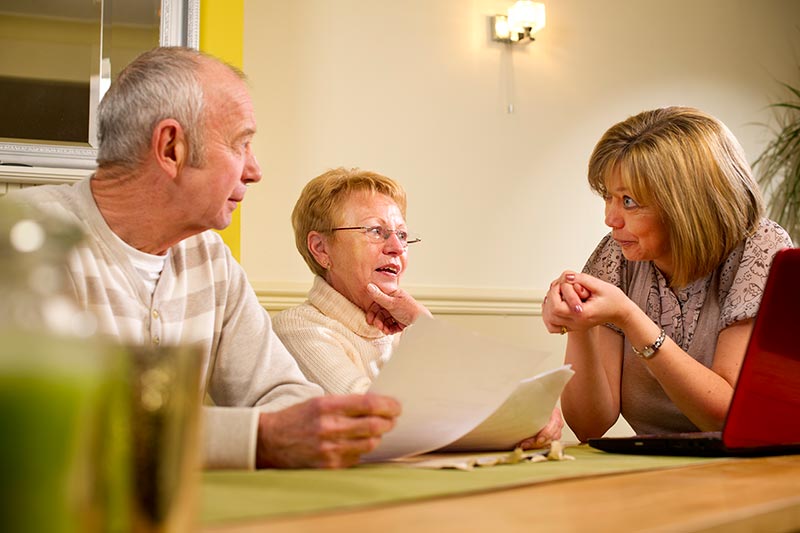 Retired couple talking to Insurance Agent, How Medicare Benefits You | Your Insurance Gal